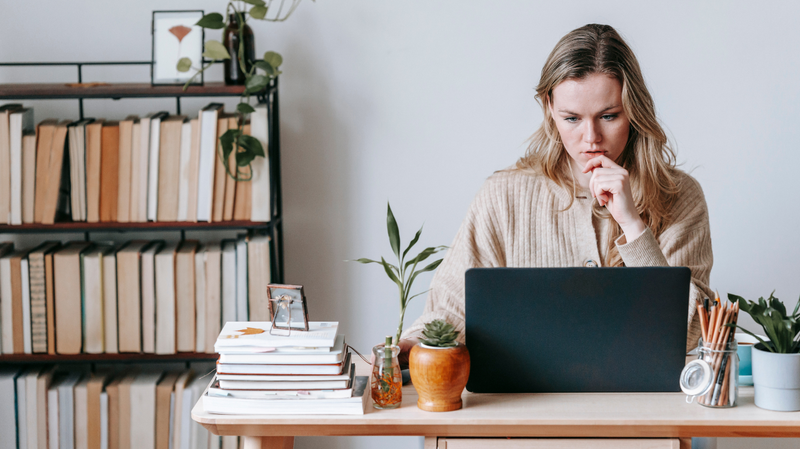 woman browsing laptop on dining table